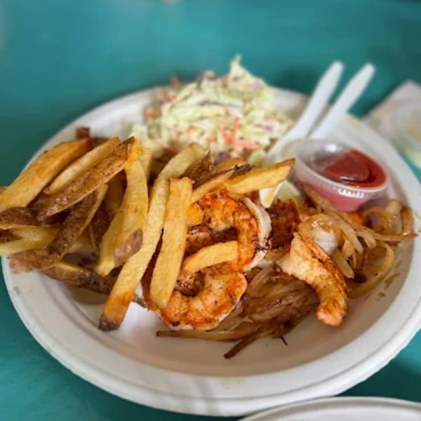 B.O.'s Fish Wagon shrimp and fries platter with coleslaw and ketchup on a white plate.